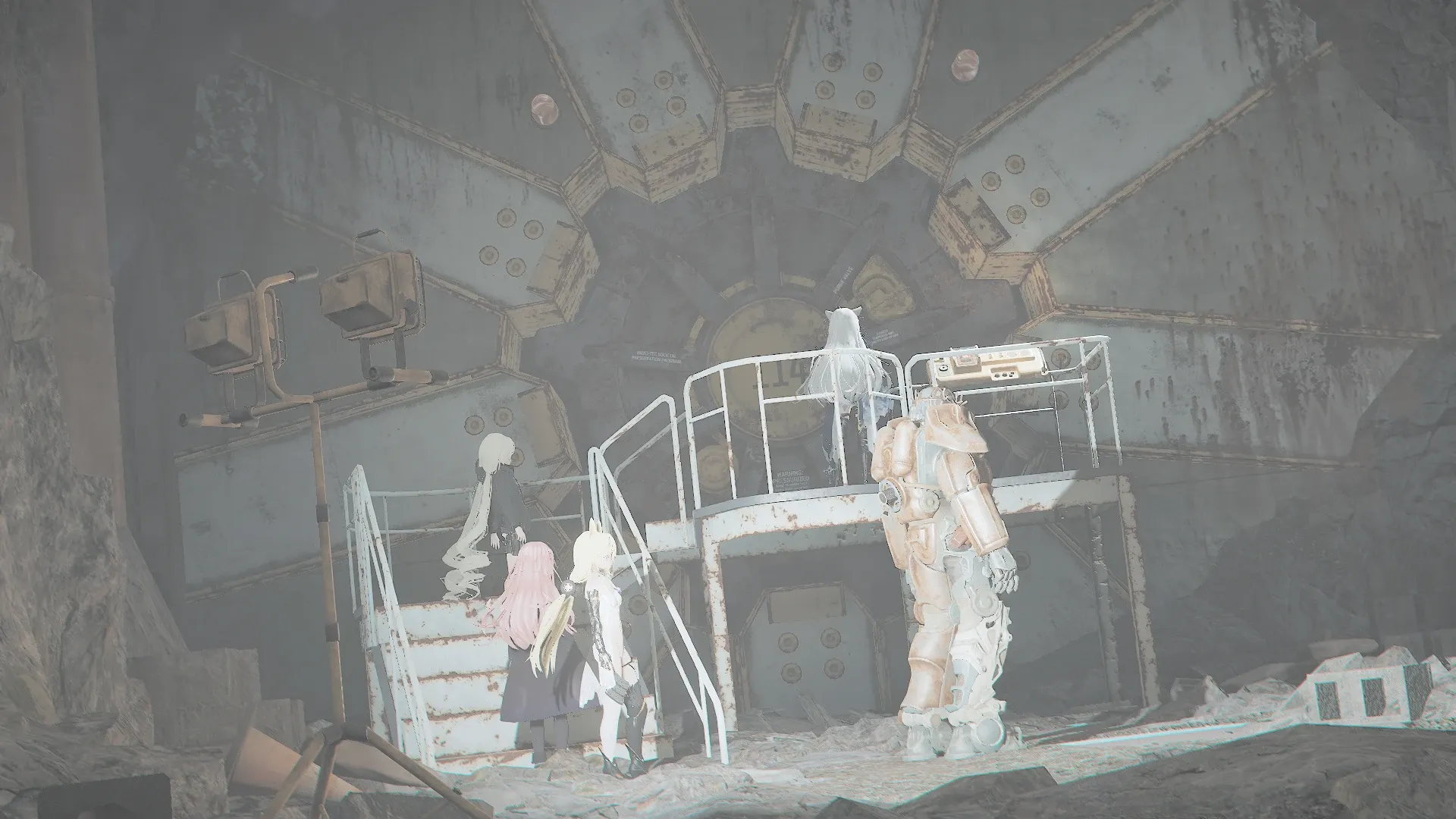 写真: Vault 114と書かれた大きな金庫の扉の前に佇む人形達